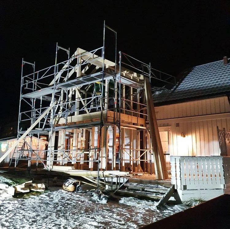 Stillaser utenfor opplyst hus i kveldsmørket