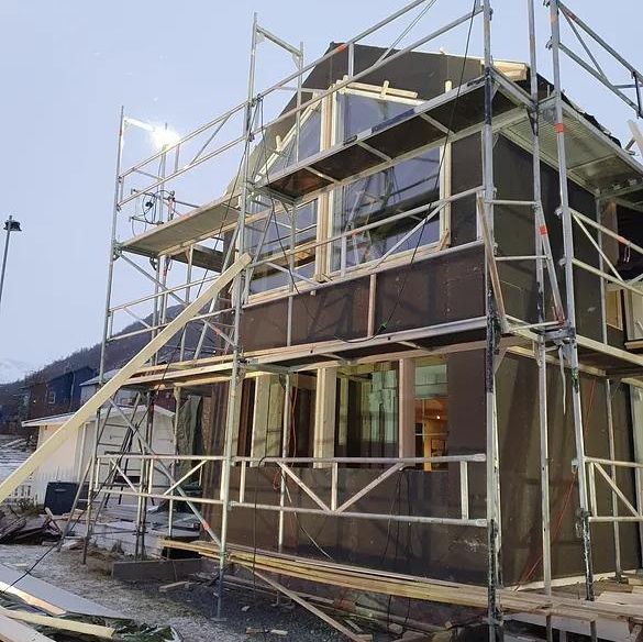 Stillaser står oppstilt utenfor nybygg med uferdig fasade